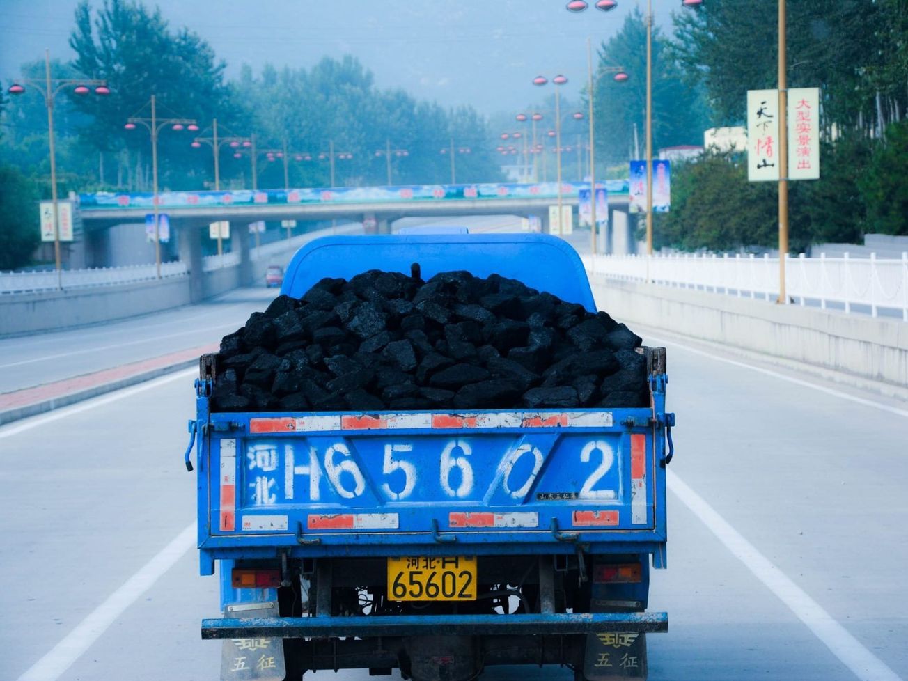 A truck carries coal in smoky, hazy Beijing.