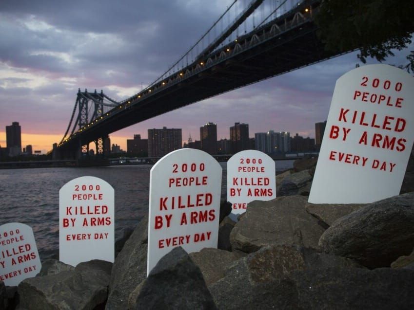 Fake tombstones placed by the Control Arms Coalition line New York's East River.