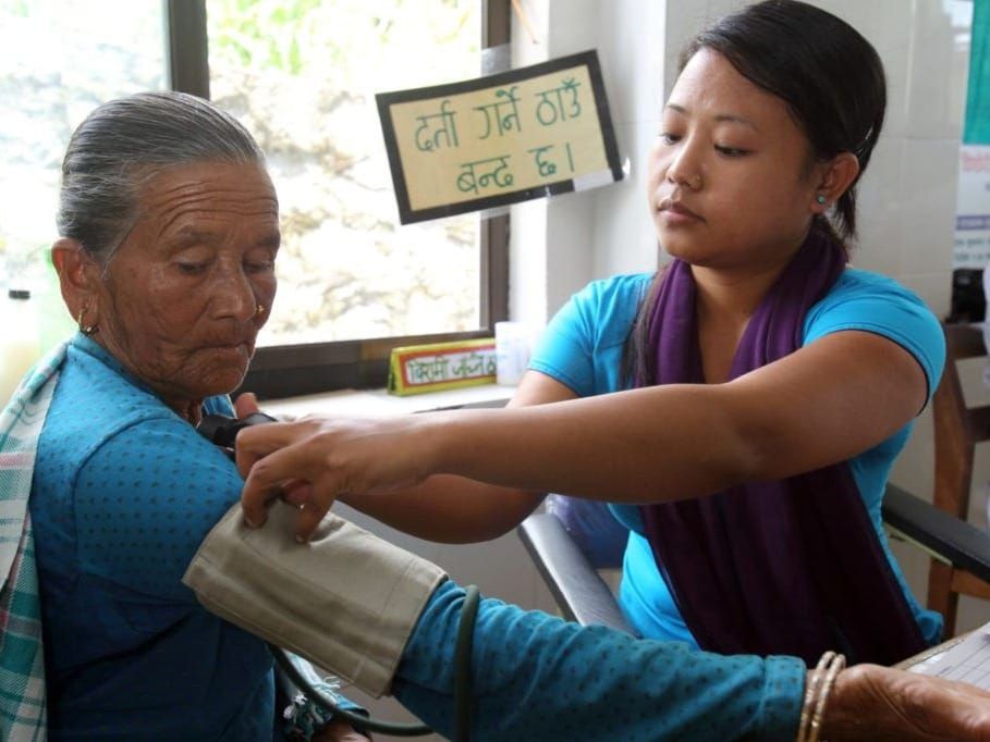 A health worker performs a blood pressure checkup at a clinic in Pokhara, Nepal