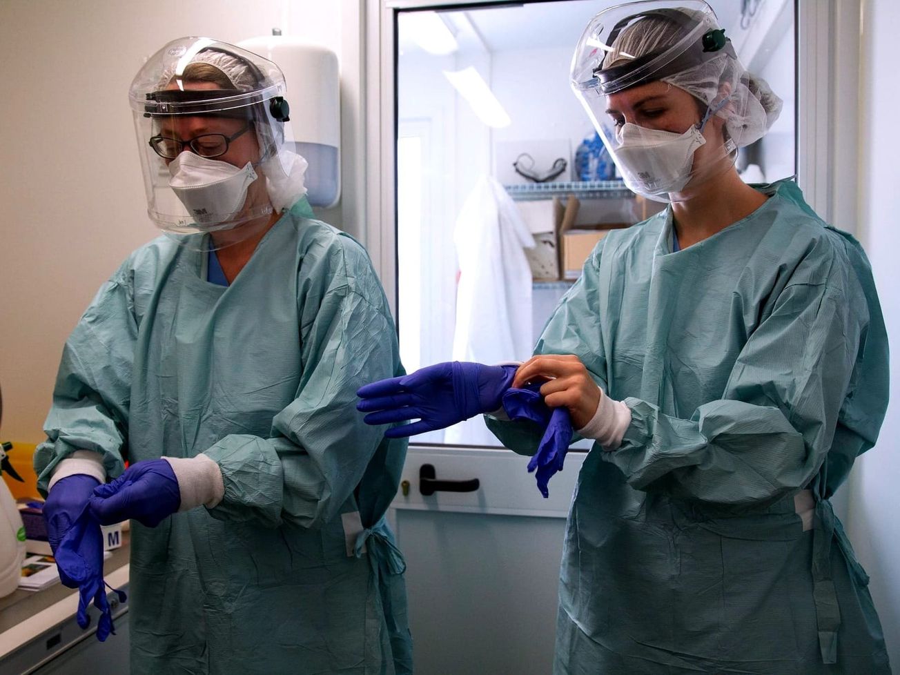 A team of lab technicians prepare to handle a sample for testing at an Ebola Treatment Unit in Liberia managed by the International Organization for Migration.