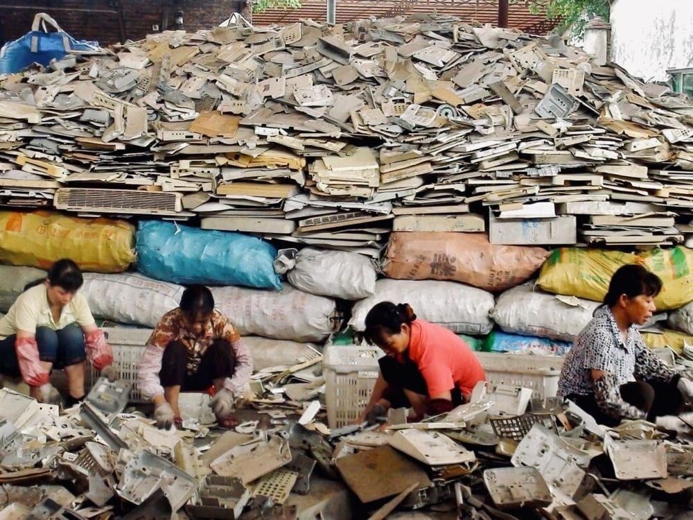 Workers sort through e-waste for melting in Guangzhou, China