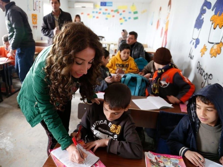 Lebanese teacher Nathalie Jaber helps a Syrian student at the Zaatari refugee camp in Jordan 