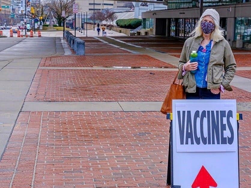 A sign on a street directs people to a COVID-19 vaccination center in downtown Baltimore, Maryland