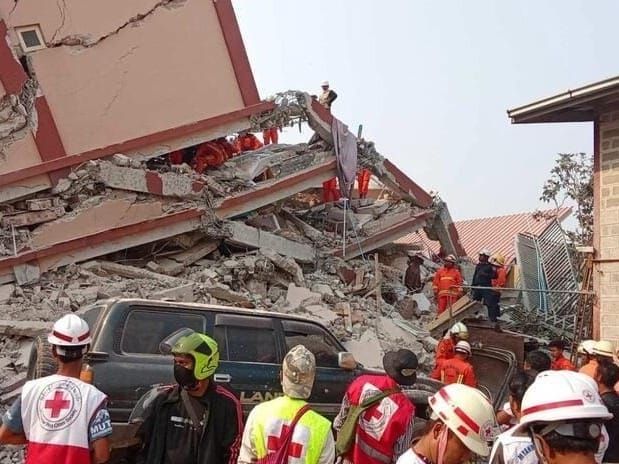 Myanmar Red Cross rescue teams look for survivors in a collapsed building.
