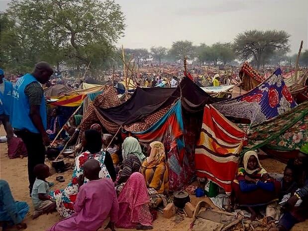 Sudanese refugees gather around makeshift tents and shelters in Chad.