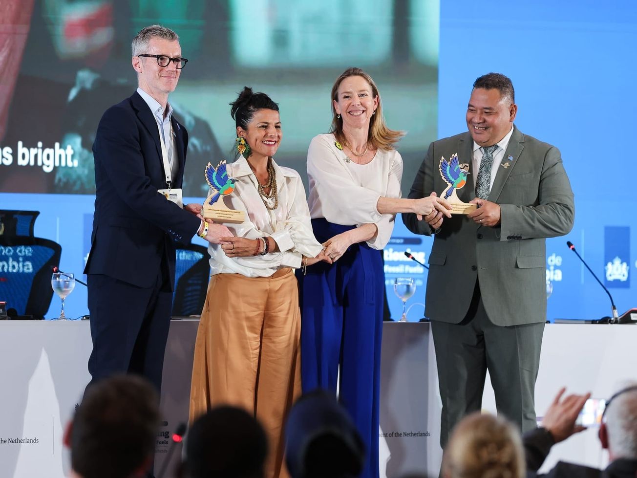 From left to right, officials from Ireland, Colombia, the Netherlands, and Tuvalu join hands at the conference.