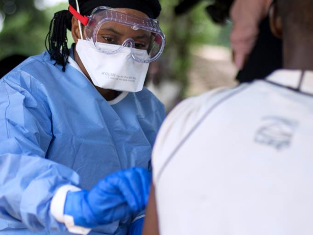 A member of the ring vaccination team in Congo vaccinates a man in Bosolo village.