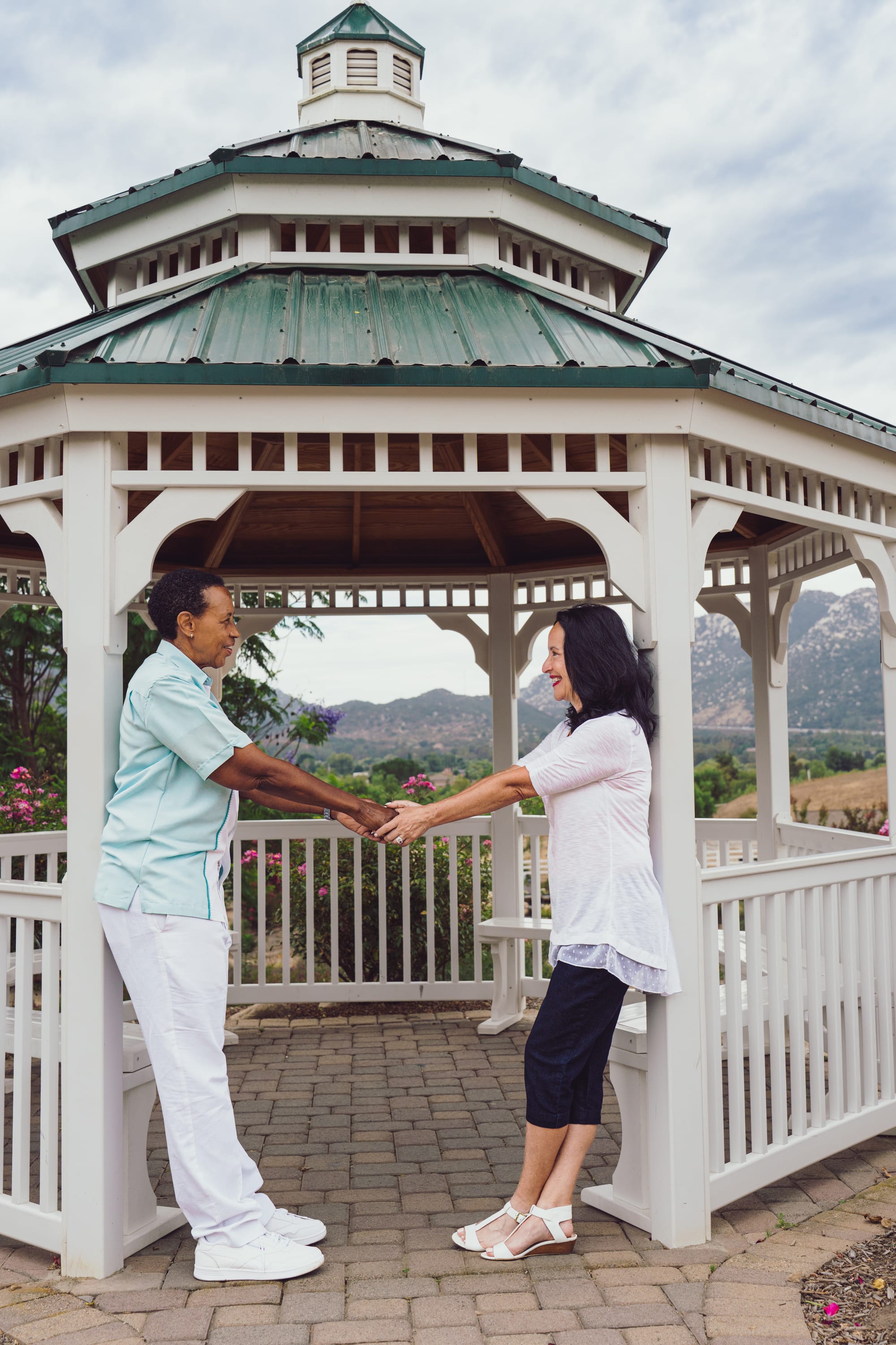 Jill and Lori of Jillori, wedding officiants and premarital mentors, holding hands under a gazebo in Southern California