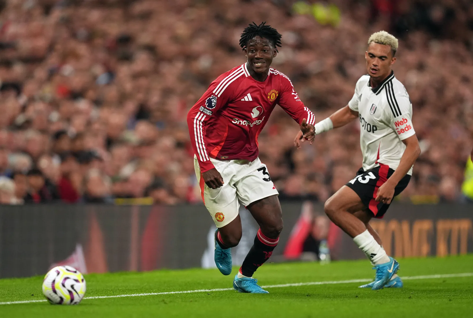 Kobbie Mainoo dribbles past Antonee Robinson of Fulham