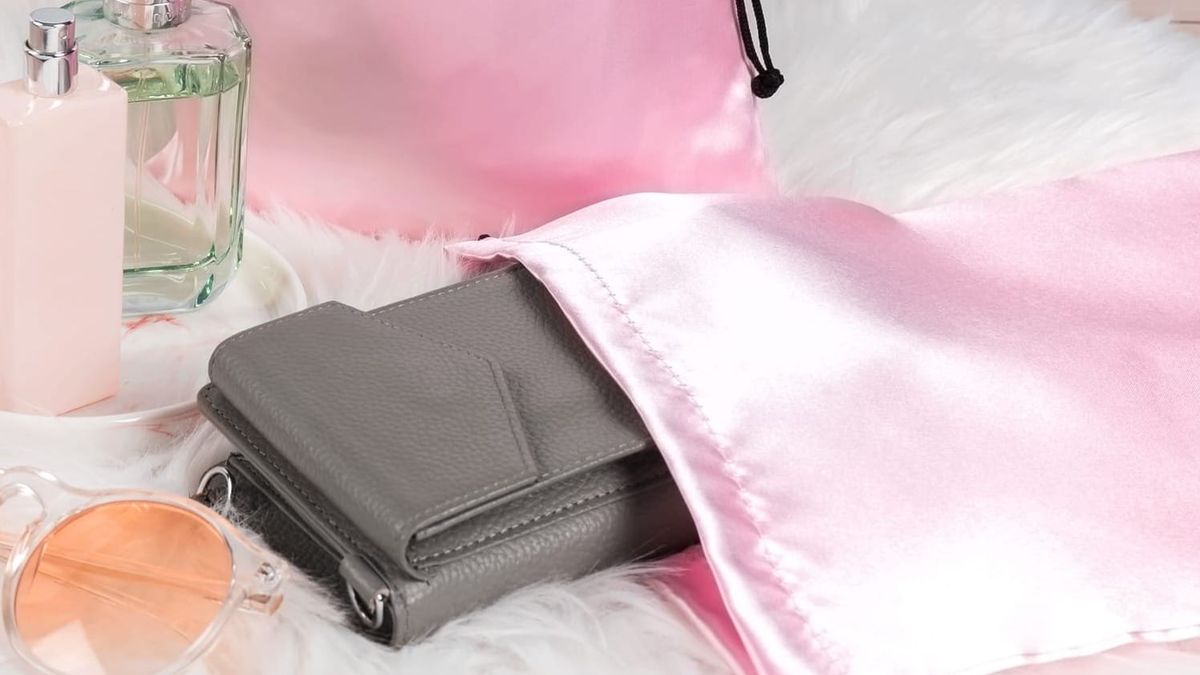 A satin bag with a wallet insight and surrounded by other knickknacks