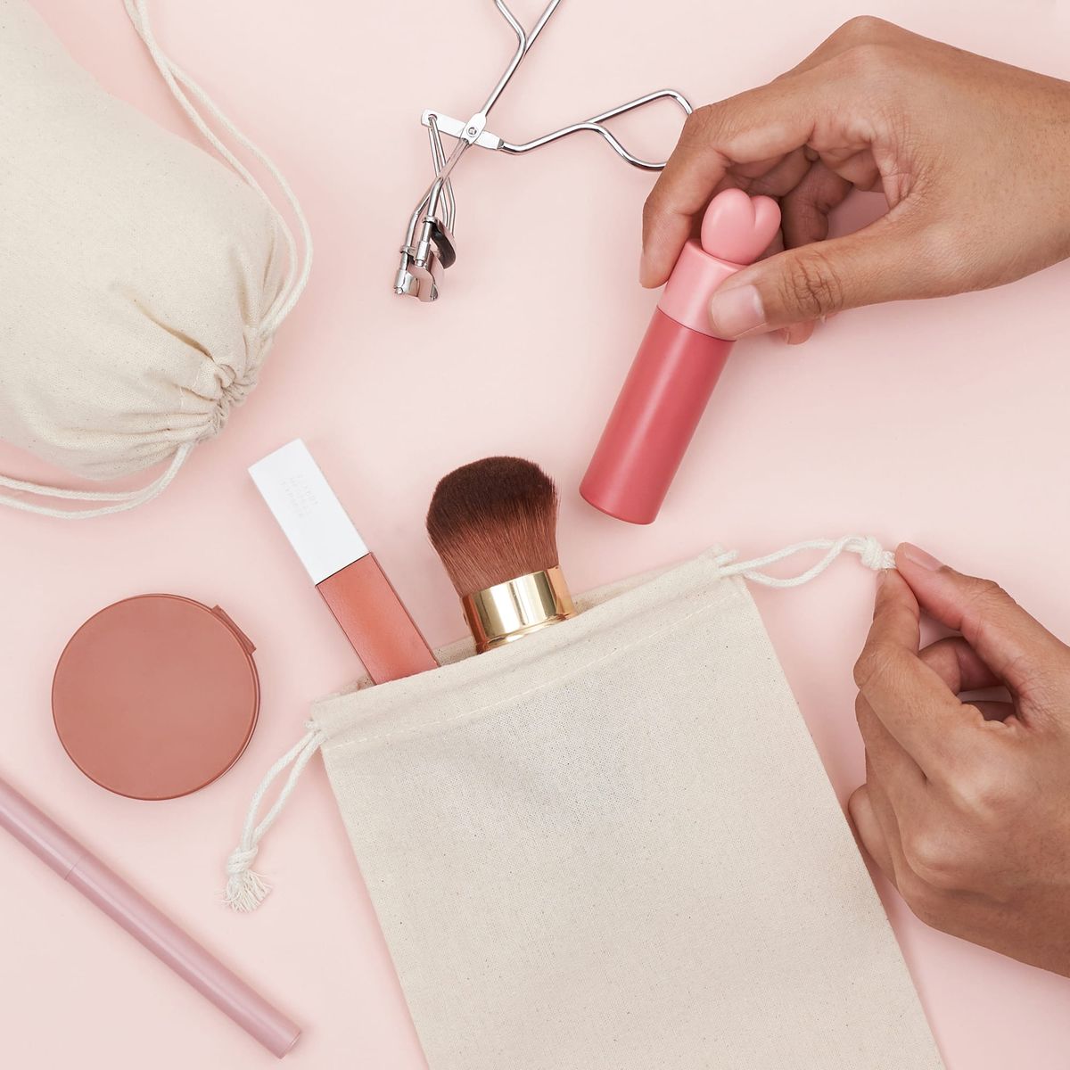 A hand organizing make up in a cotton bag