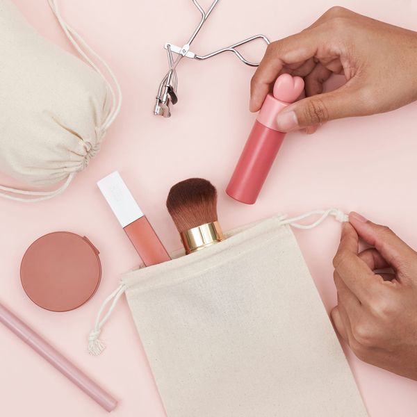 A hand organizing make up in a cotton bag