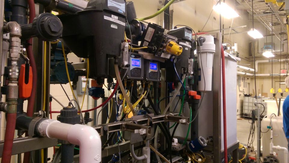 Lots of tubes, screens and cords, as in a lab, greys black and whites with red and yellow accents