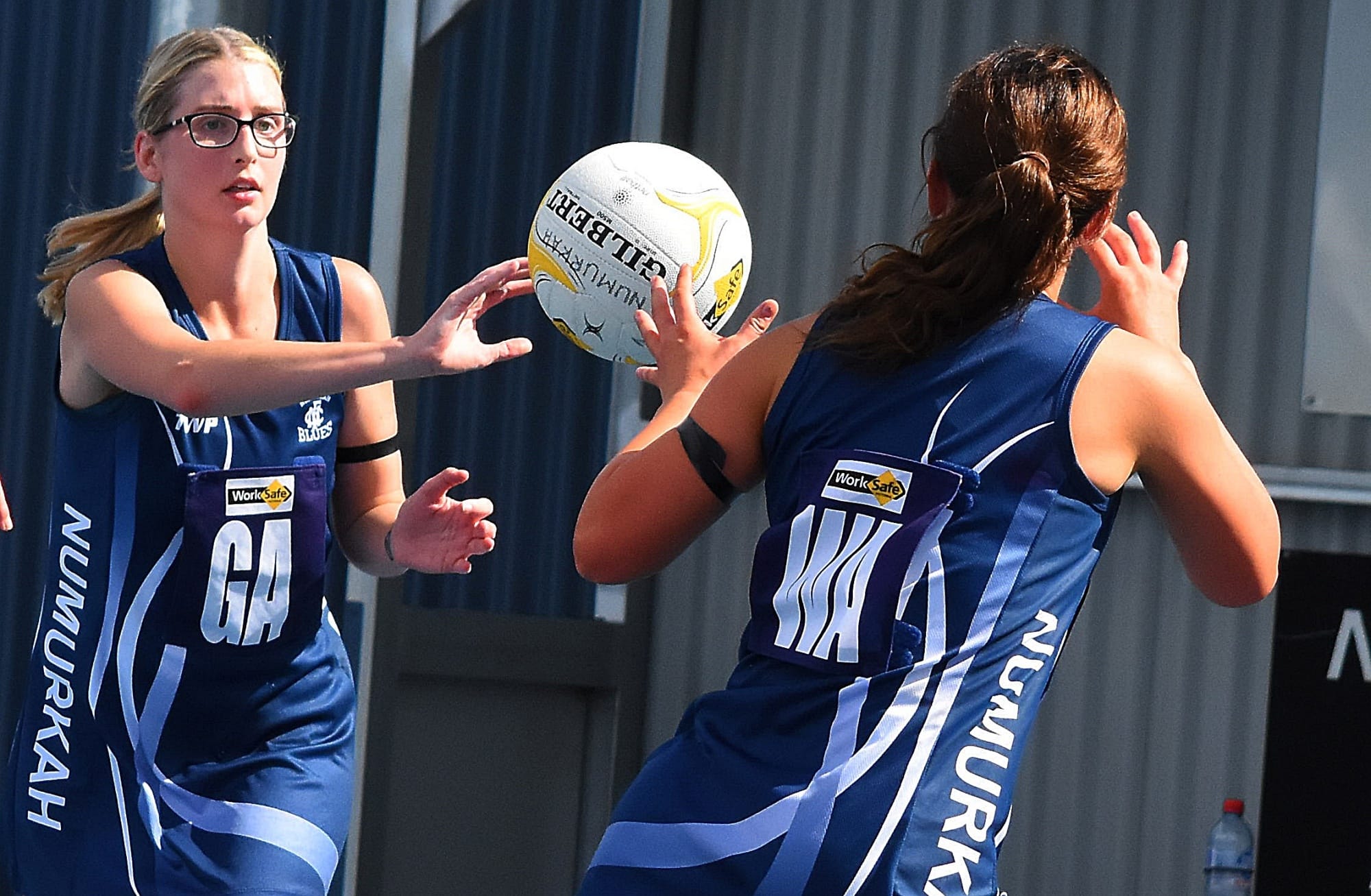 Teamwork... Ebony Hicks (left) fires a pass to Chelcee Schubert in B-grade. 