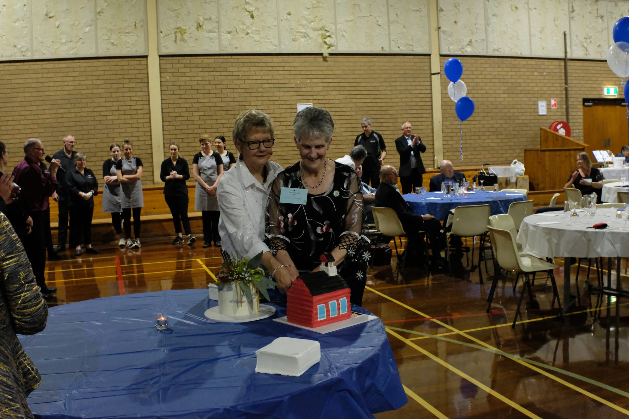 Sweet memories ... Kaye Crane and Cheryl McKenzie cut a cake in the likeness of the original school building.