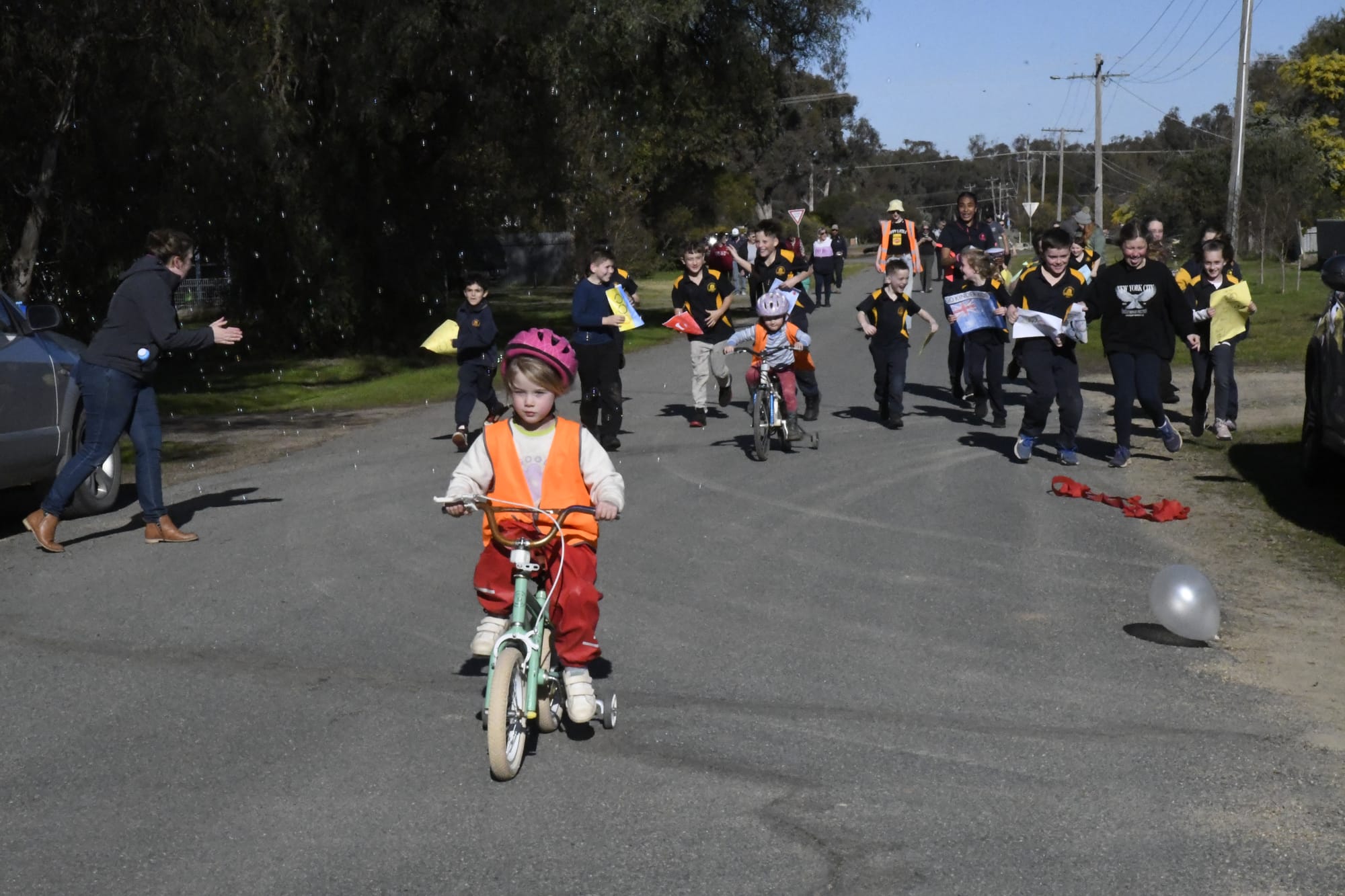 Bringing it home... The final riders head to the finish line with the encouragement of their cheer squad from Katamatite Primary School.