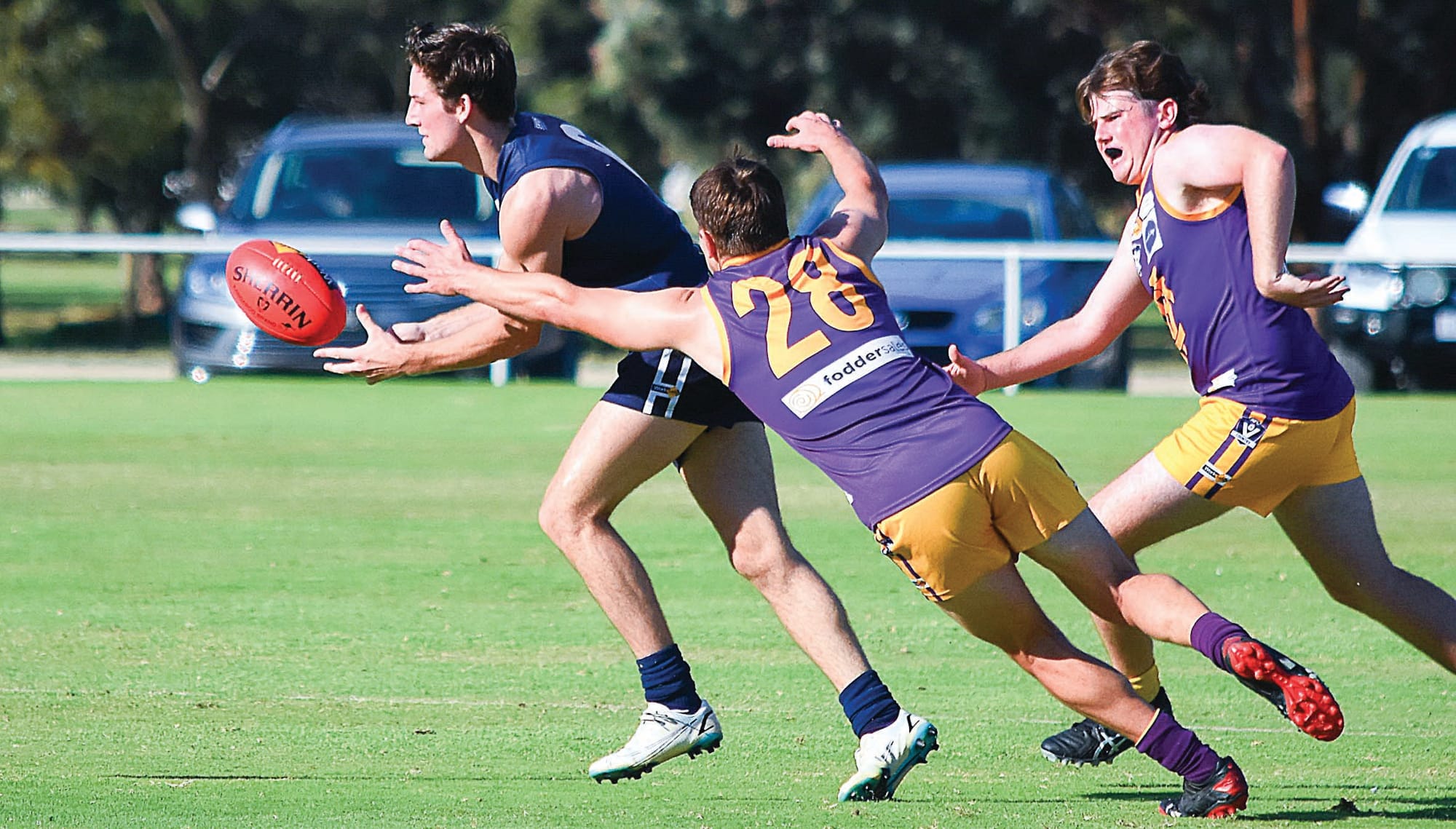 Pressure... Jarrod Holmes gets his handball away before being tackled by Ben Armstrong. 