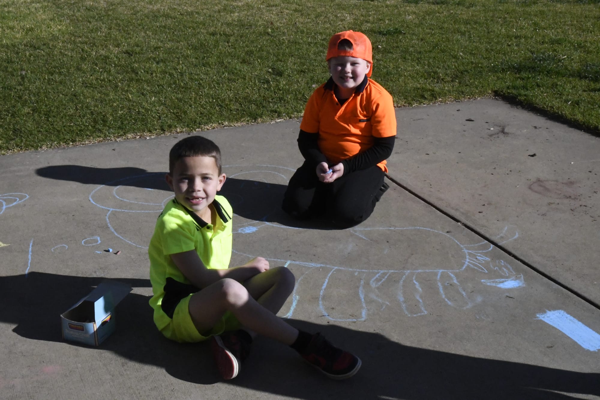 Bright eyed and bushy tailed... Lincoln McRae (left) and Alec Bartlett work on creating a 100 legged creature out of chalk on day 100.