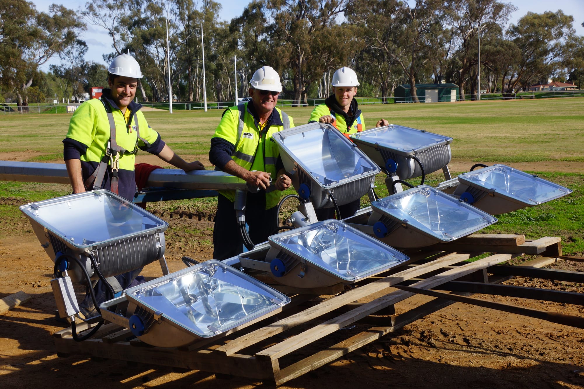 Team effort ... Coach Mal Barnes (left) and captain Tom Nihill (right), help their boss Andrew Sim wire up the lights.