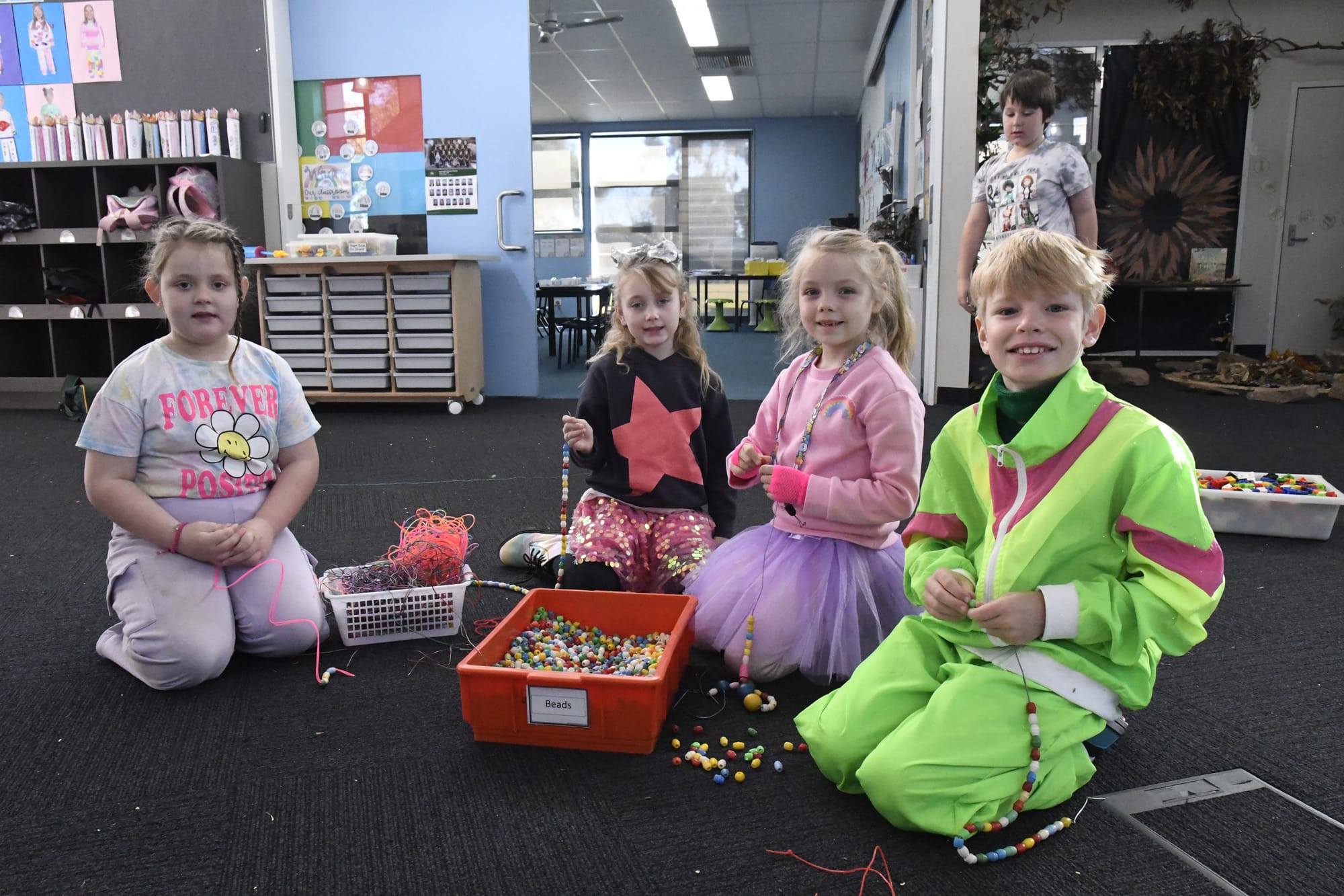 Bright and happy... (From left): Alison McKean, Jayda Elsegood, Lilly Meany and Nick Codiga get into the spirit by threading 100 beads on a string.