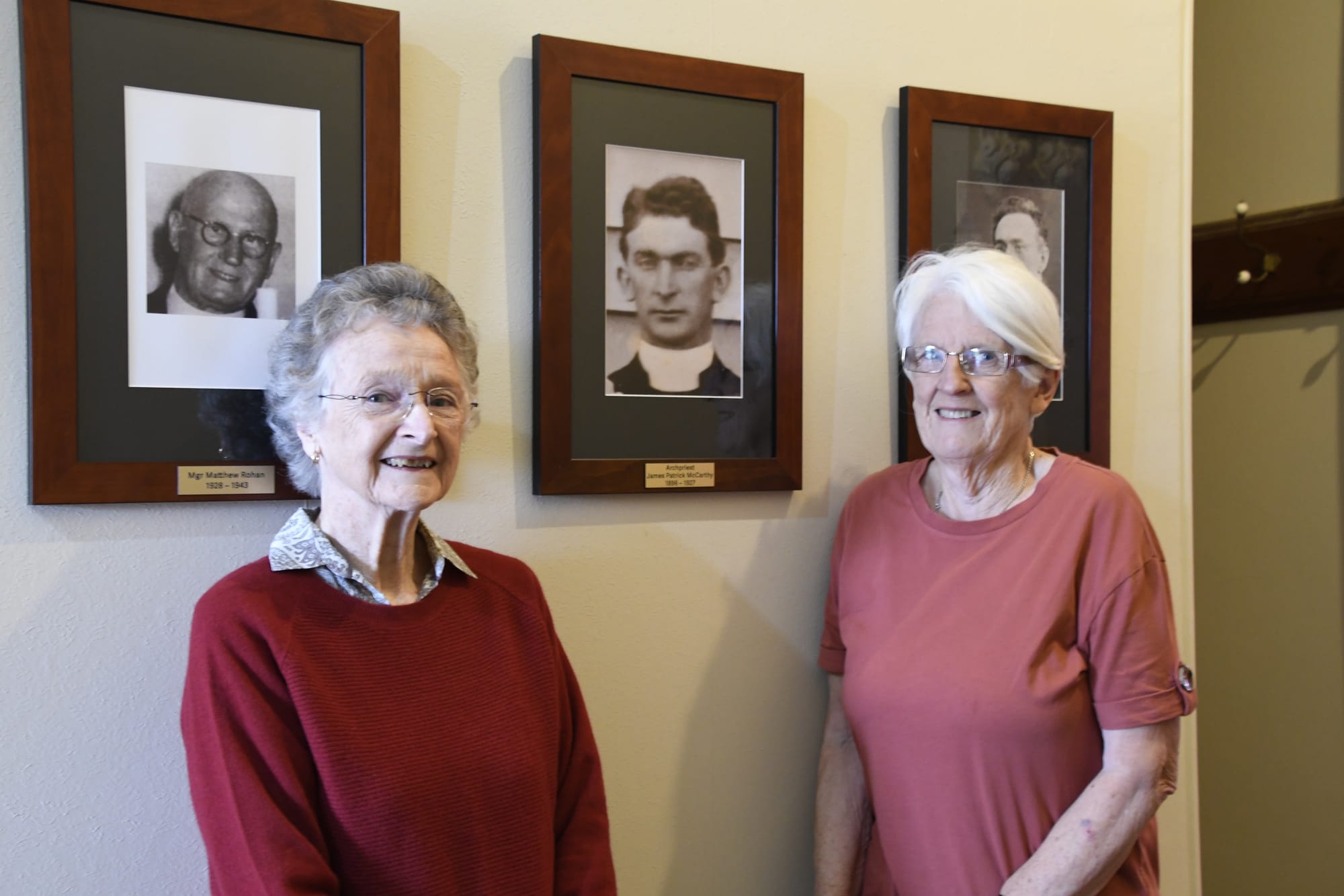 Home at last ... Dorothy Farrant and Tricia Newman are pleased to have finally been able to add Fr McCarthy’s portrait to the gallery of St John’s parish priests. 