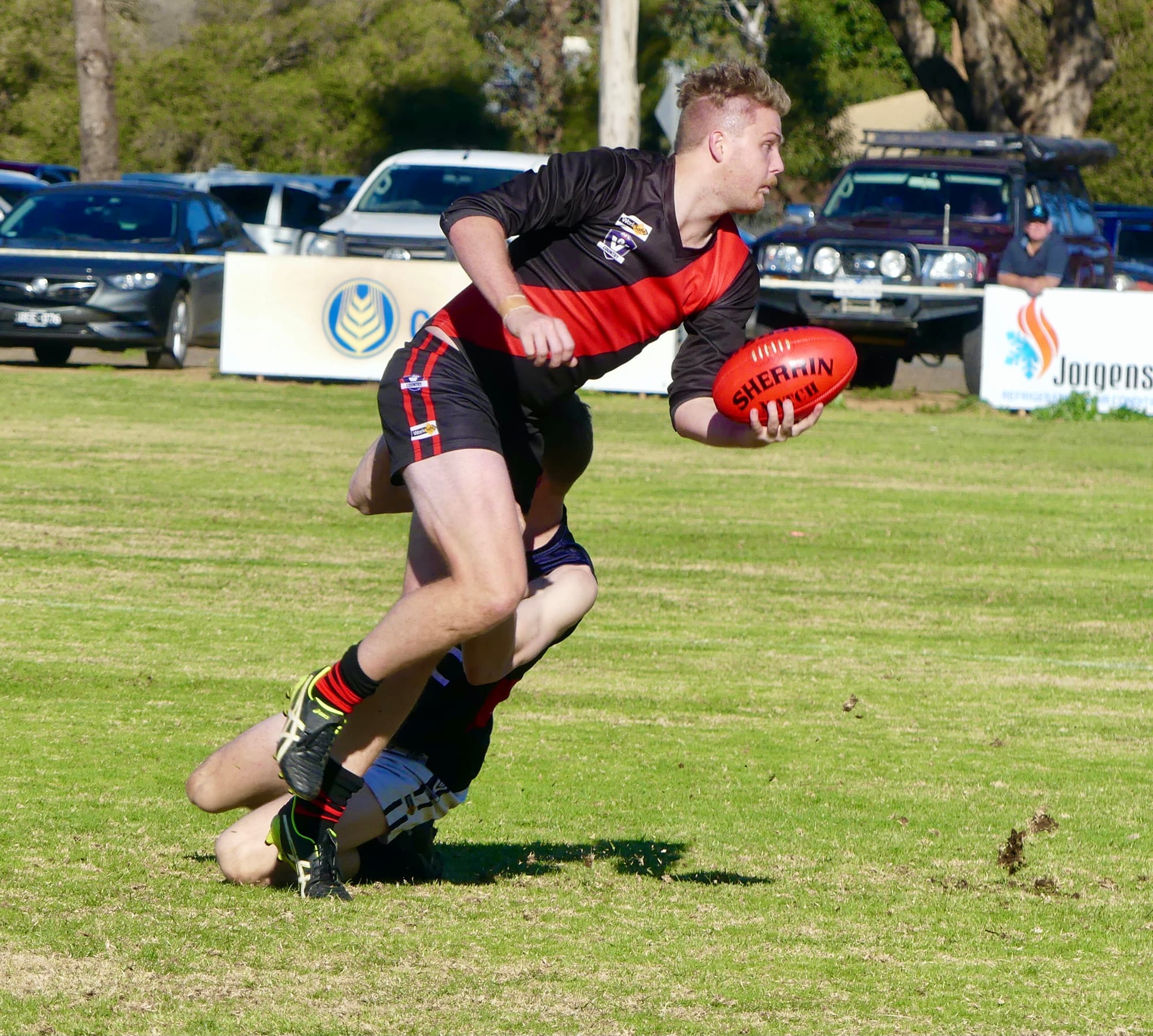 Got it away ... Jesse Trower flicks a handball away while being tackled.
