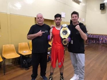 Winner... Marcus Davis holds up the light welterweight Victorian title belt with trainer Scott Maskell (right) and Maskell’s dad, Mick (left).
