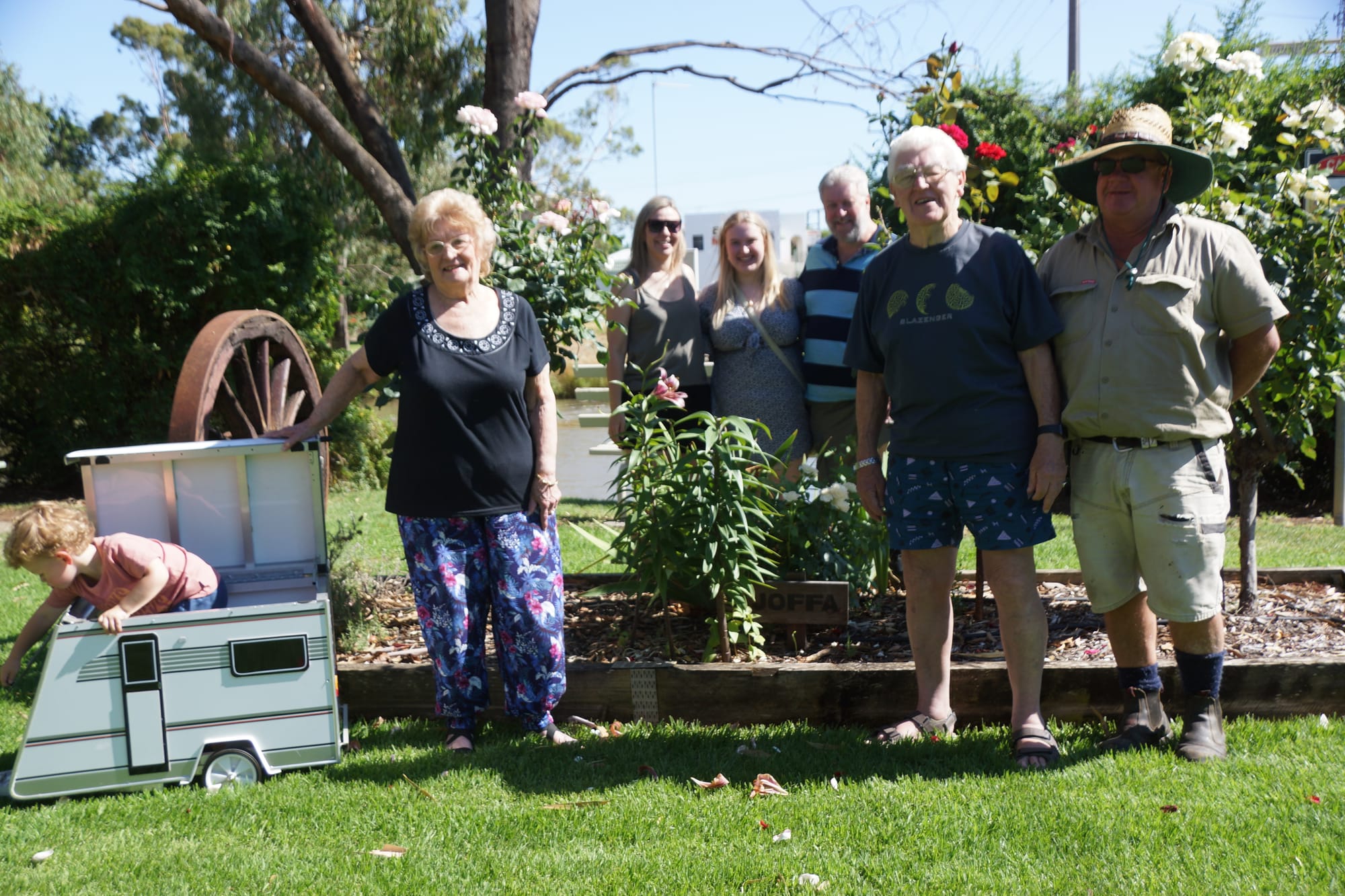 Home away from home... (From left): Lachie, Pat, Lisa, Abby, Paul and Johnny Curran, and Russell Harbor enjoy Joffa’s flower bed at Numurkah Caravan Park. 
