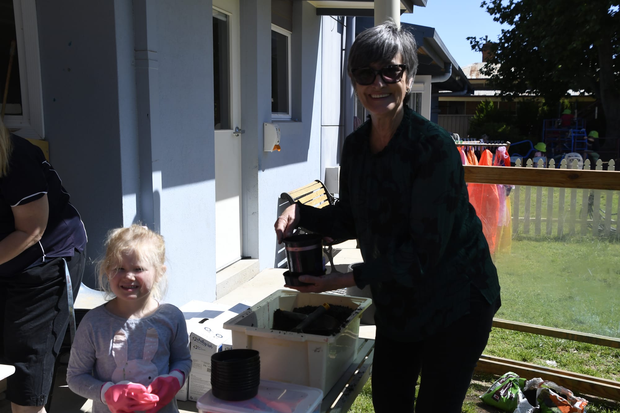 Helping hand ... Harper Gledhill gets a hand with filling her pot with dirt from Deb Fowler. 
