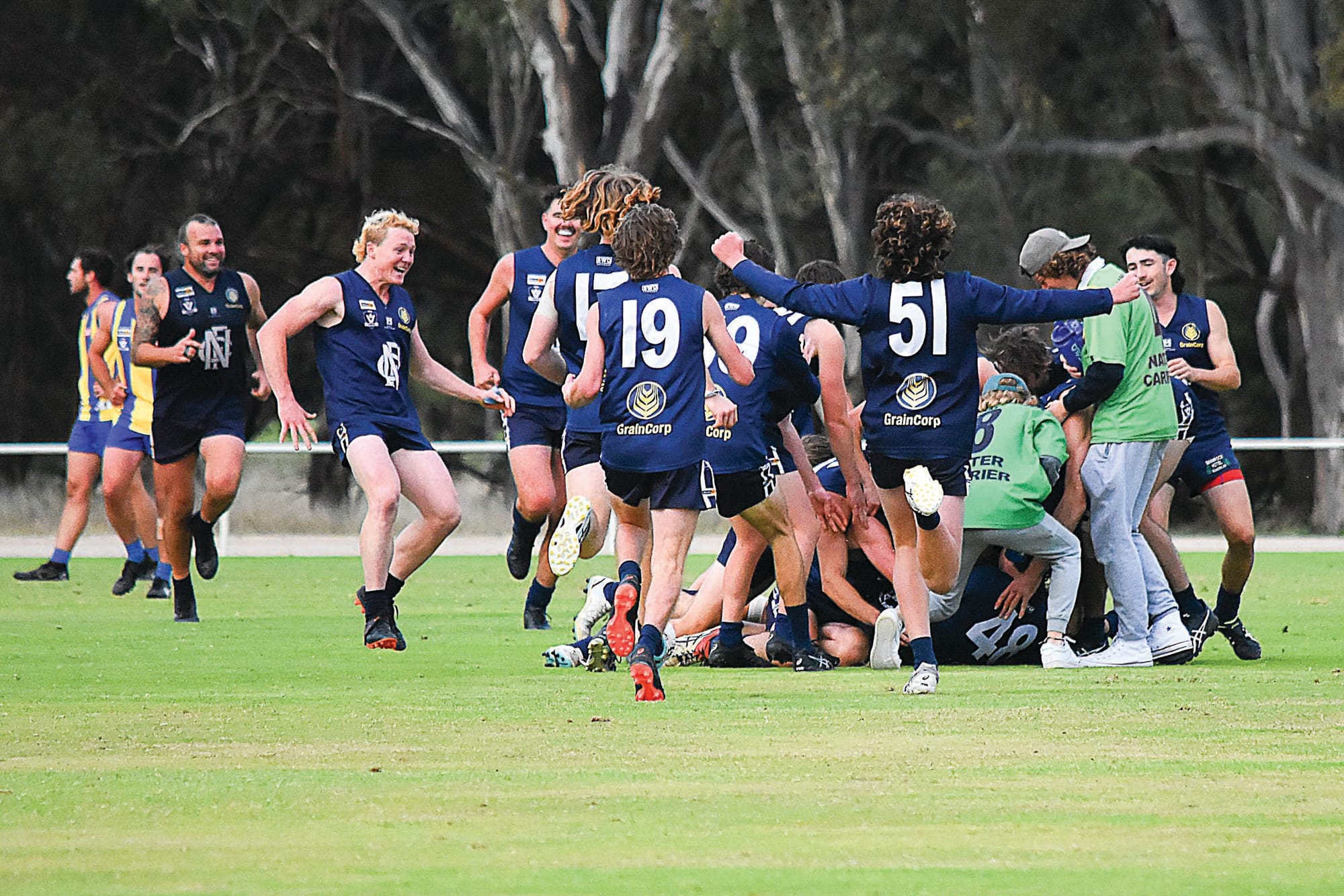 Mobbed... Players came from everywhere to celebrate after Verhoeven’s kick after the siren. 