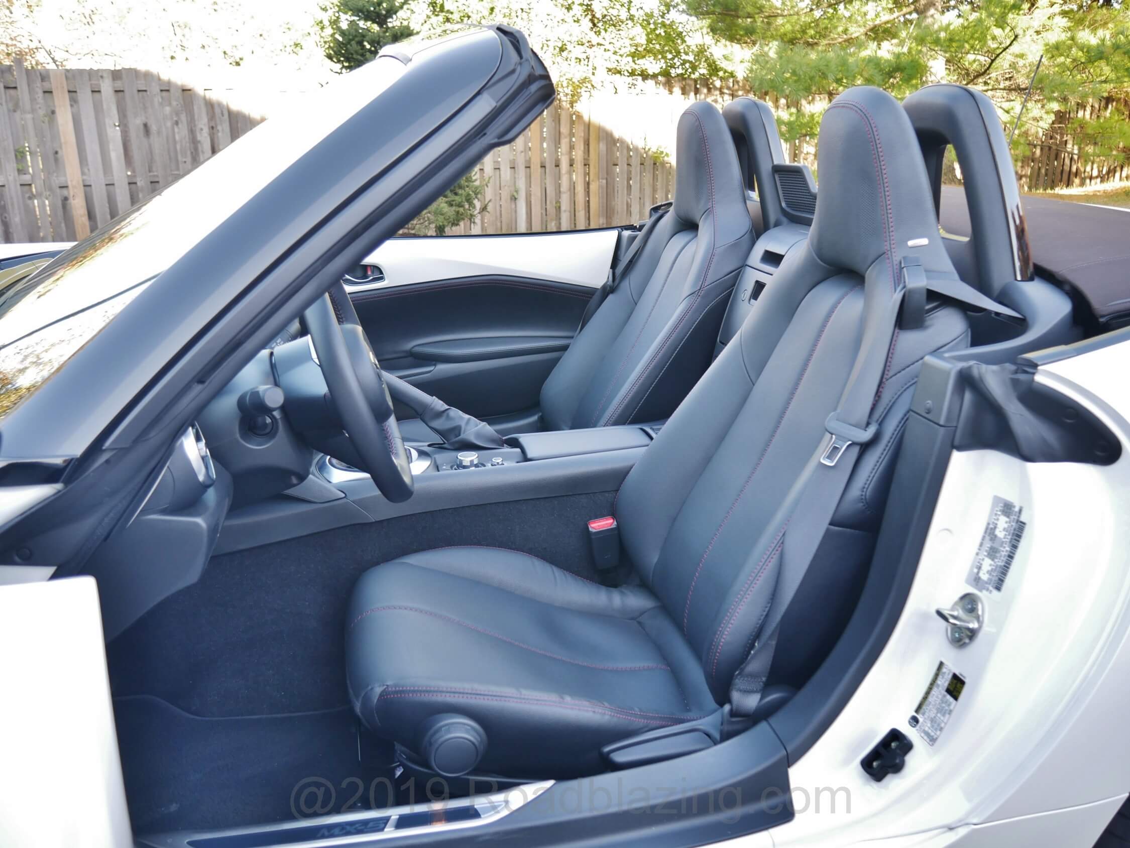 2019 Mazda MX-5 Grand Touring: Leather trimmed and heated bucket seats, decent of bolstering, narrow of breadth. Tilt steering wheel, now also telescopes suiting taller drivers, who position the seat farther aft.
