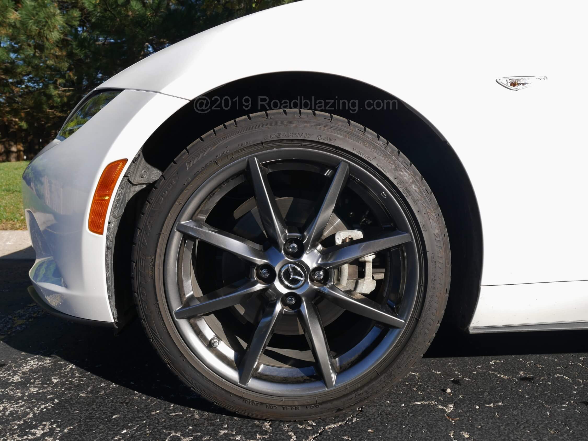2019 Mazda MX-5 Grand Touring: 3- season rubber on 17" smoked alloys match with an independent suspension tuned for street civility and a bit of track understeer / oversteer, complemented by sharp steering transmitting road surface and linear fade free brakes