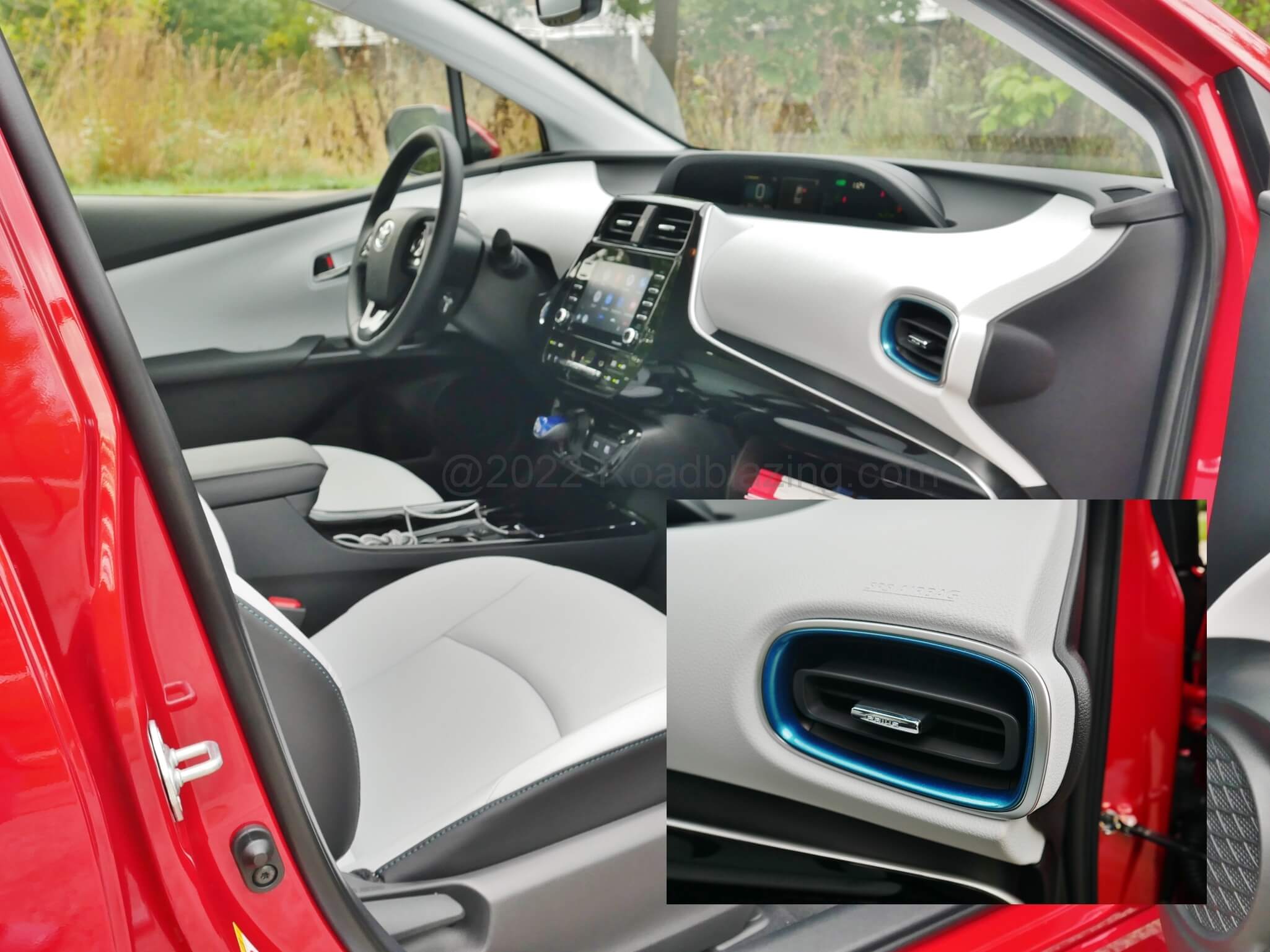 2022 Toyota Prius XLE AWD-e: contrasting accents include blue ring climate vents with toggle "PRIUS" inscription