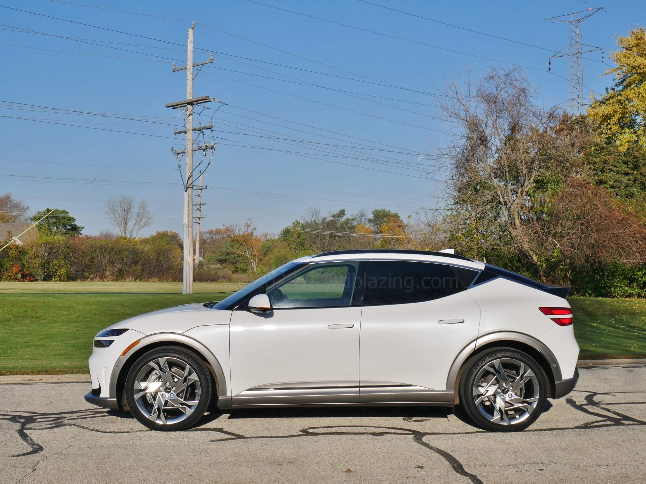 2022 Genesis GV60 Performance AWD EV: Flared semi darkened wheel arches contrast with the Uyuni white tall beltline coke bottle fuselage issue sport to this utility wagon.