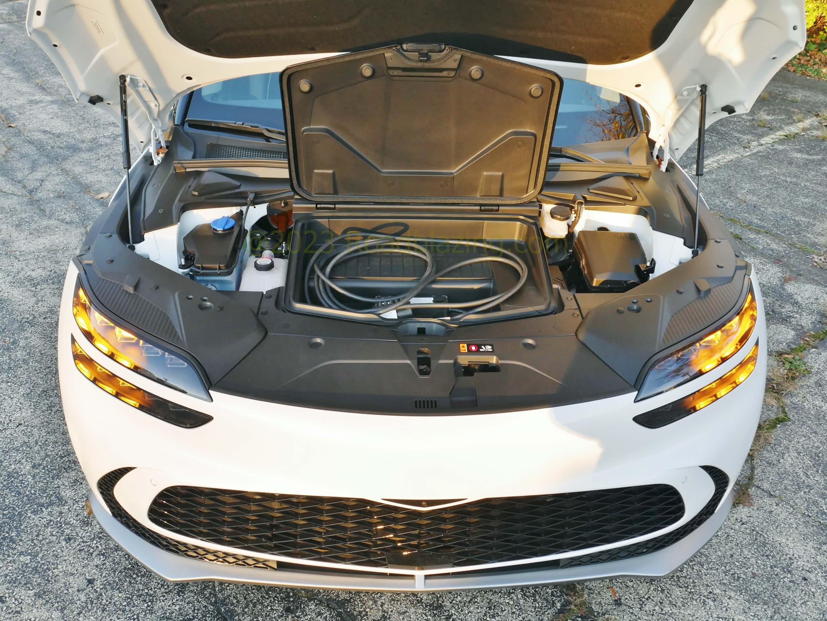 2022 Genesis GV60 Performance AWD EV: small frunk above front synchronous AC motor drive unit which combines with the rear for 426 hp / 516 lb-ft