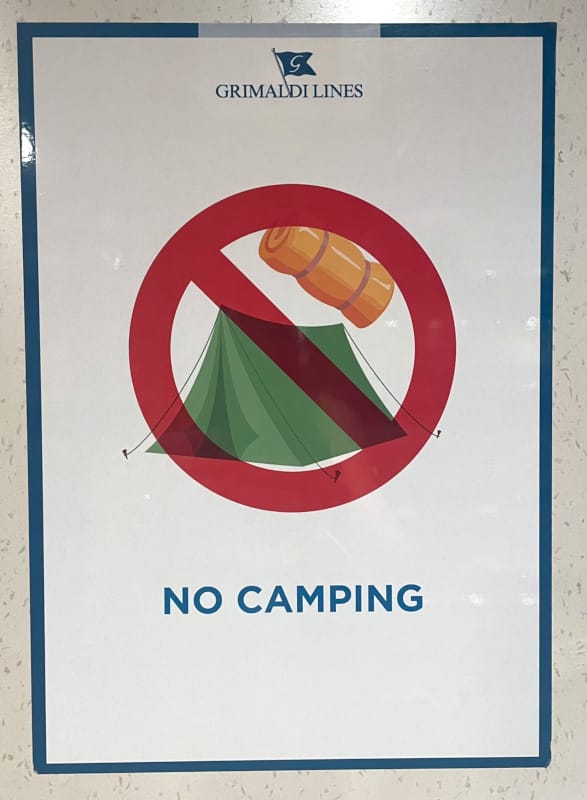 Illustration on a ferry poster showing a crossed-out tent with the text “No Camping” – indicating that camping on board is prohibited.