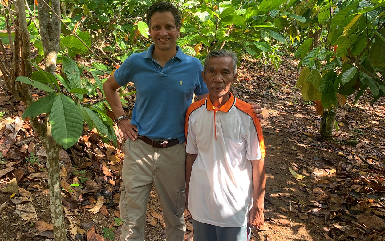 Image shows Nicko Debenham visiting  an Indonesian cocoa farmer during his time as a sustainability officer