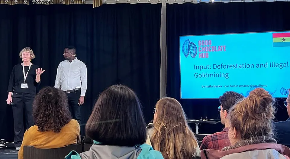 Image shows Andrea Hüsser from The Good Chocolate Hub introducing Issifu Issaka for his session on illegal goldmining