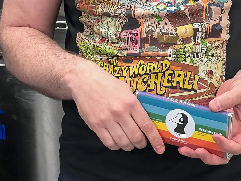 Image shows man holding a Taucherli and wearing the t-shirt