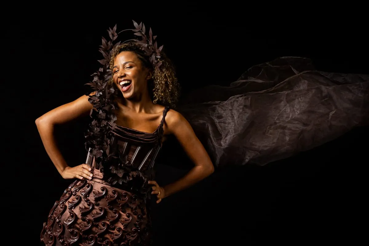 Image shows a model showcasing a chocolate-inspired dress at on the Salon du Chocolat catwalk.