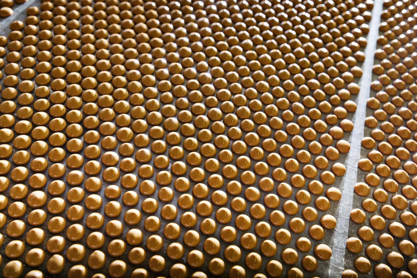 Image shows a production line of chocolate beads to illustrate AI technology