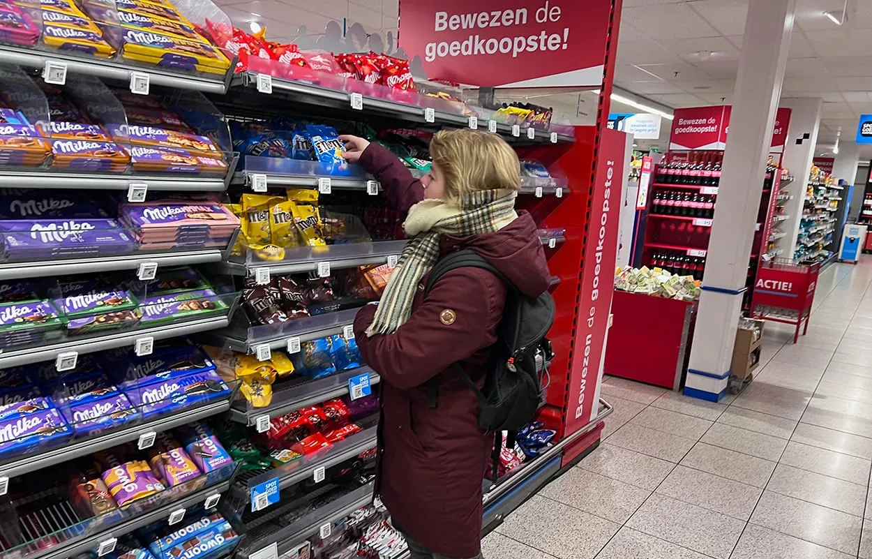 Image shows a shopper buying chocolate in a supermarket in The Netherlands.