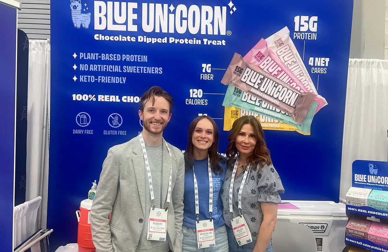 Image shows Robert Bell and the team from Blue Unicorn at their booth at Sweets & Snacks Expo. Image: cocoaradar.com