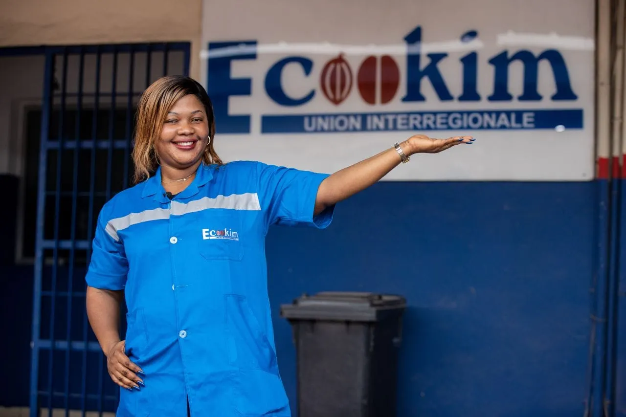 Image shows a reprsentative of the Ecookim cooperative proudly showing off its building.