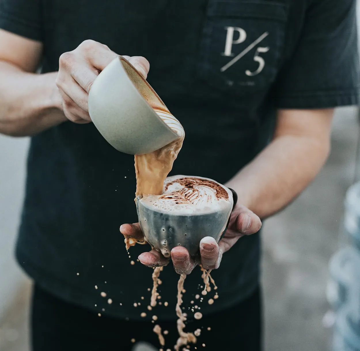 Image shows a barrista pouring hot chocolate into a cup.