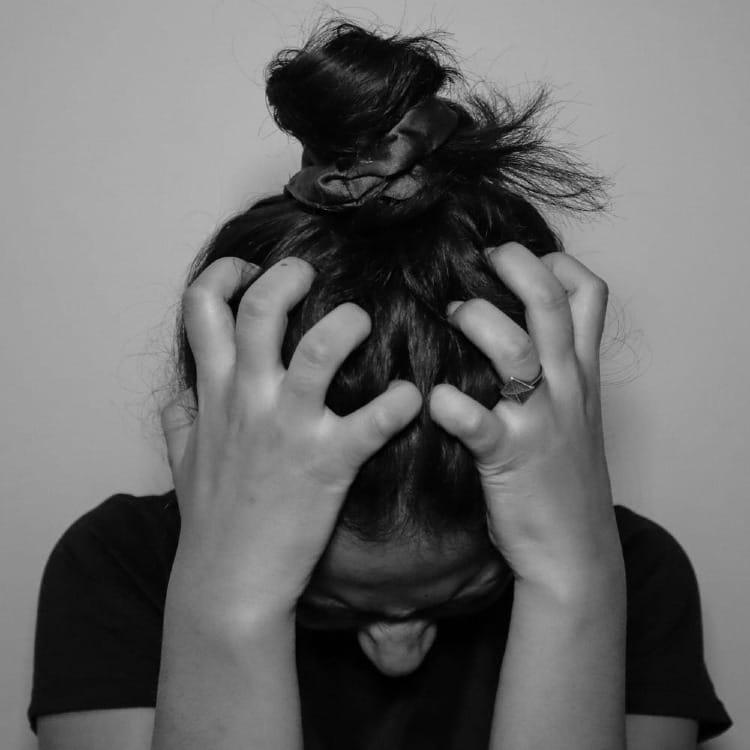 a woman covering her face with her hands