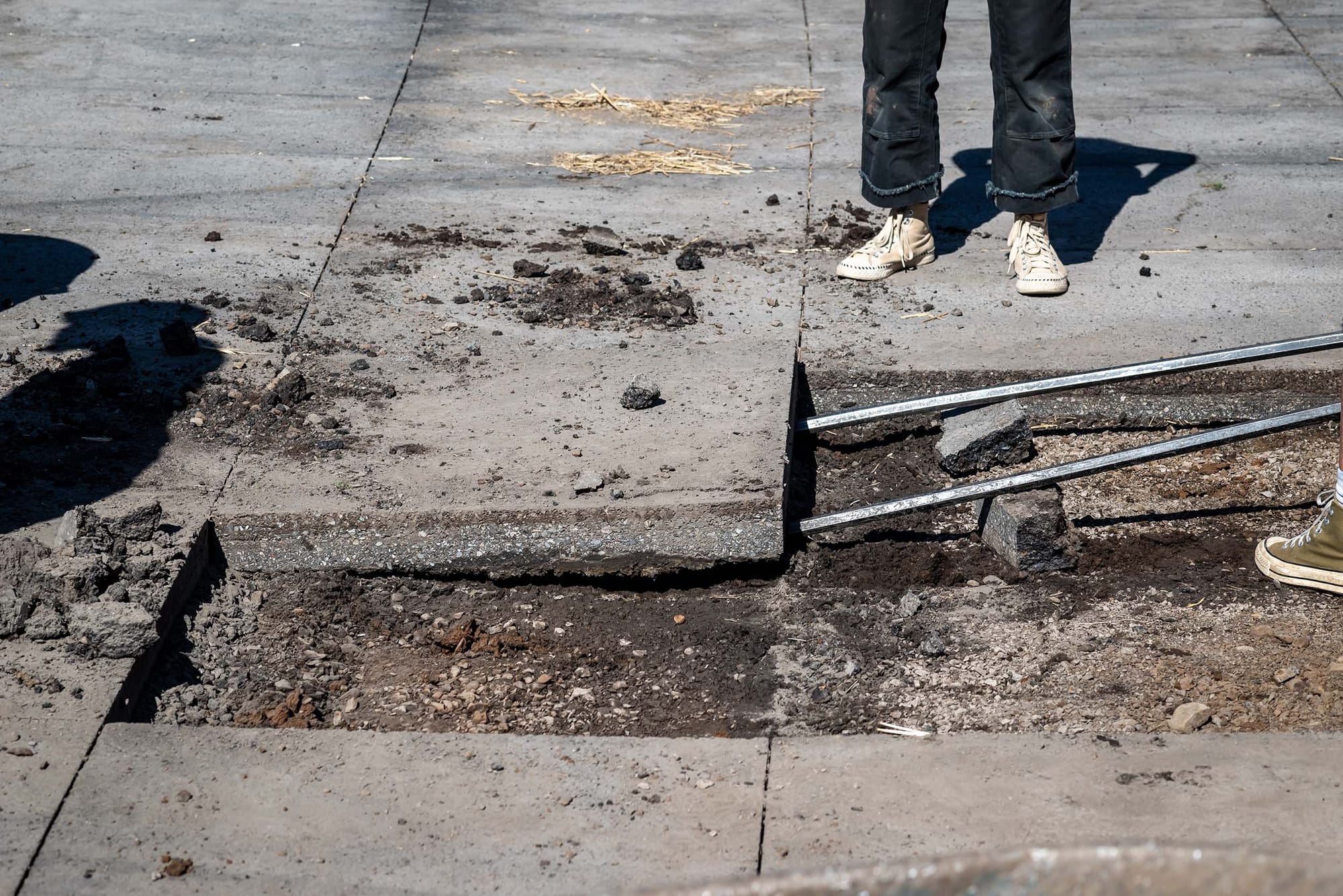 Closeup of outdoor pavement that's been cut into blocks and is being removed