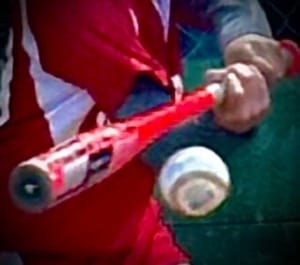 red bat about to connect with baseball