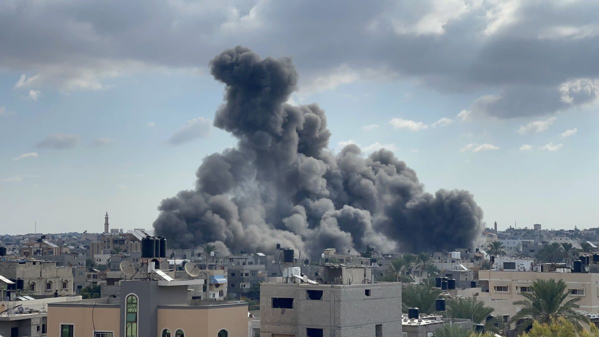 En stor røyksøyle stiger mellom boligblokker i Gaza by under luftangrep.