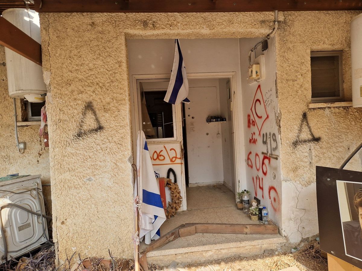 Et skadet hus i kibbutzen Kfar Aza med israelsk flagg ved døren, to år etter angrepet 7. oktober 2023